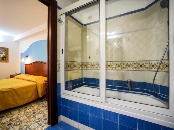 Bagno e camera da letto in Hotel Amalfi con piastrelle mediterranee