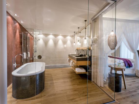 Modernes Badezimmer im Seezeitlodge Hotel & Spa mit freistehender Badewanne und Holzfußboden