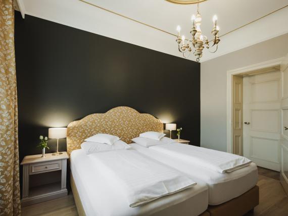 Hotel Adria room with two single beds, nightstands, and lighting