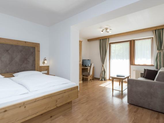 Helles Hotel Waldsee Zimmer mit Doppelbett und Sitzbereich