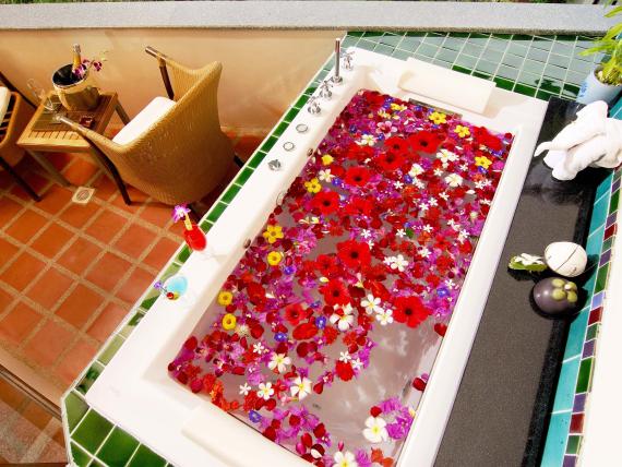 Bathtub with floating flowers at The Mangosteen Ayurveda & Wellness Resort