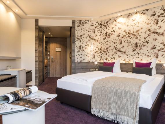 Modernes Doppelzimmer im Land & Golf Hotel Stromberg mit dekorativer Wand und Fernseher