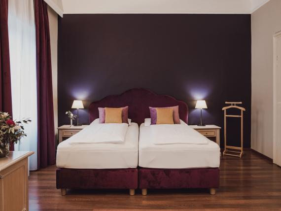 Double room at Hotel Adria with purple beds and cozy decor