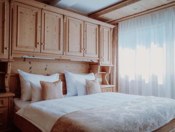 Gemütliches Schlafzimmer mit Holzvertäfelung im Das Verwall Lech Hotel