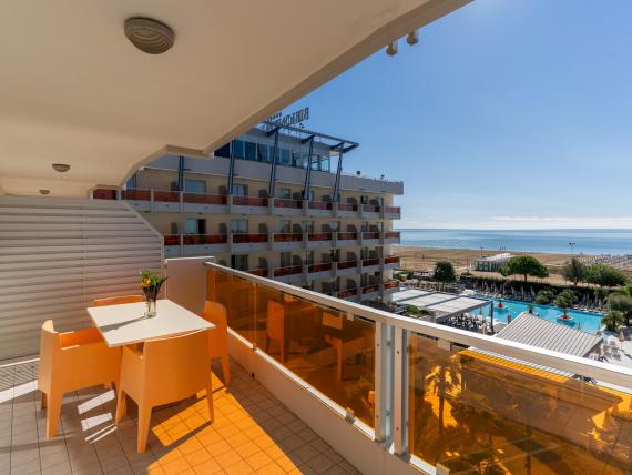 Balcone con tavolo e sedie al Bibione Palace Hotel con vista su piscina e spiaggia