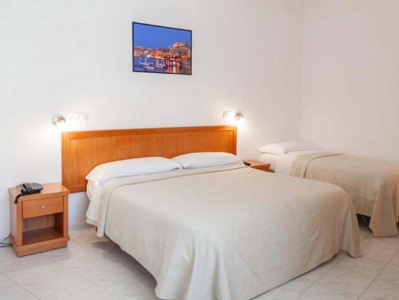 Camera Hotel Viola Gaeta con letto matrimoniale e singolo, pareti semplici
