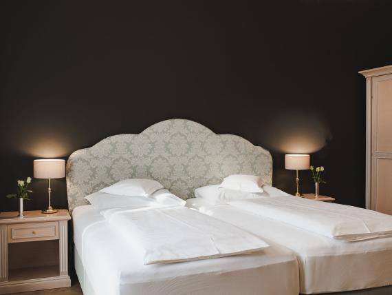 Double room at Hotel Adria with two beds and bedside tables with lamps