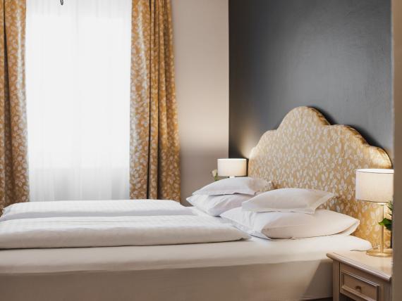 Elegant Hotel Adria room with double bed and traditional chandelier
