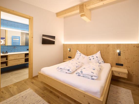 Schlafzimmer mit Holzvertäfelung und Zugang zum Bad im Hochfeldhof