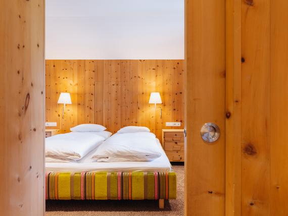 Gemütliches Doppelzimmer im Hotel Aurora mit Holzvertäfelung und warmem Licht