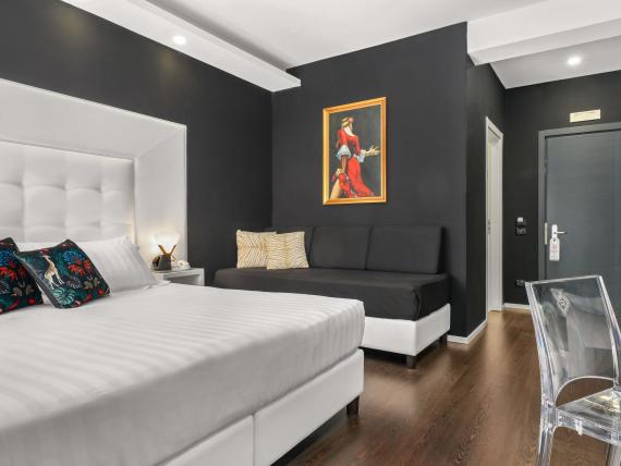 Camera d'albergo moderna al Reggia Suite Spa Hotel con letto bianco e parete nera