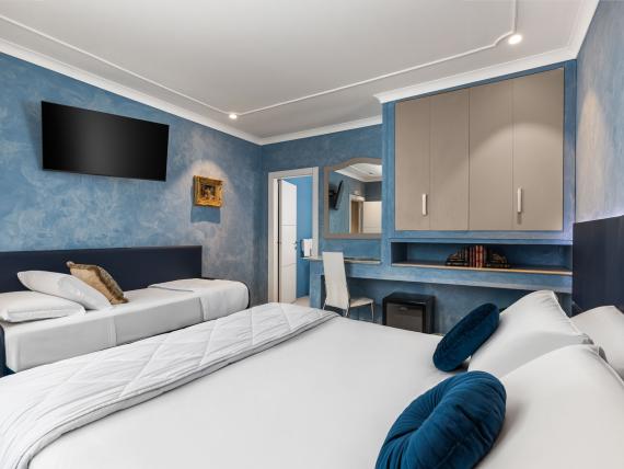 Camera moderna con letto matrimoniale e singolo all'Hotel Regina Caserta