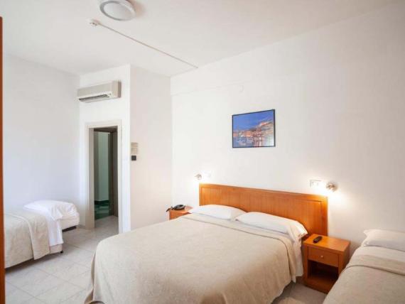 Camera con letto matrimoniale e singoli all'Hotel Viola Gaeta con arredi chiari