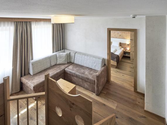 Living area in Familienresort Buchau with sofa and view into bedroom