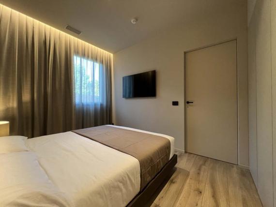 Camera da letto moderna a Evangelisti Palace Suite & Apartments con TV e pavimento in legno