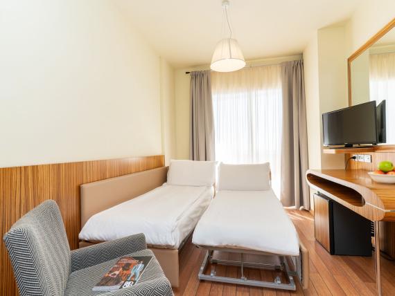 Camera doppia con letti singoli al Bibione Palace Hotel con TV e poltrona