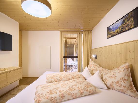 Gemütliches Schlafzimmer mit Holzdecke und Bett im Hochfeldhof