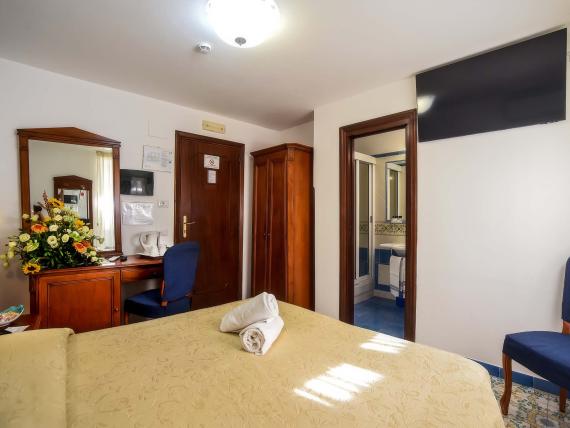 Camera accogliente con scrivania e fiori all'Hotel Amalfi