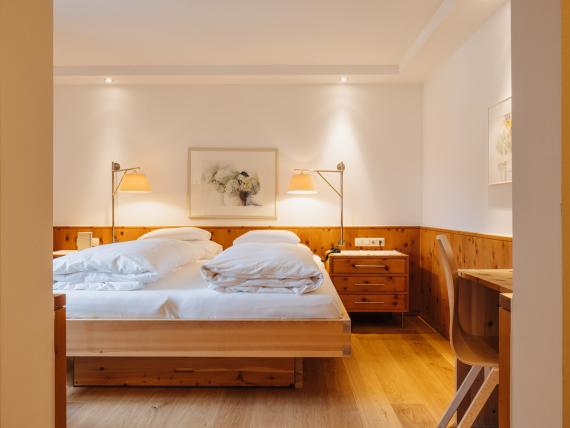 Hotel Aurora gemütliches Zimmer mit Doppelbett und Holzmöbeln