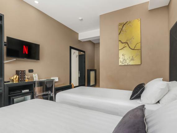 Camera moderna con due letti al Reggia Suite Spa Hotel