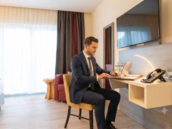 Geschäftsmann arbeitet im Mythenresort Heimdall Hotelzimmer an Laptop