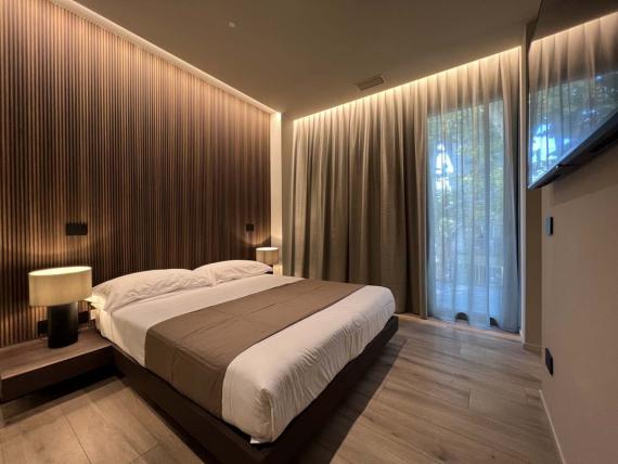 Camera da letto moderna della Evangelisti Palace Suite & Apartments con parete in legno.