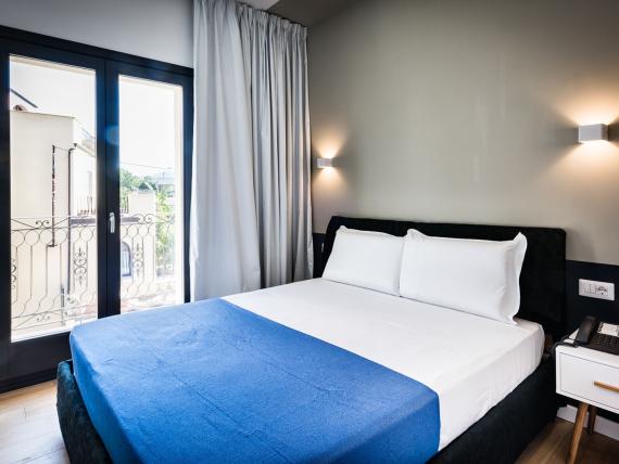 Letto matrimoniale con coperta blu al Teku Boutique Hotel