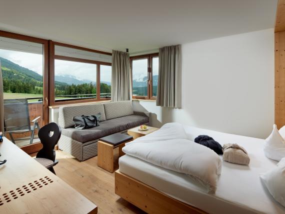 Gemütliches Zimmer im Naturhotel Die Waldruhe mit Bergblick und Sofa