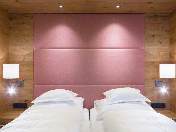 Hotel Panorama: Doppelzimmer mit zwei Betten, Holzverkleidung und rosafarbenem Kopfteil