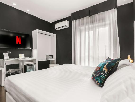 Camera moderna al Reggia Suite Spa Hotel con letto grande e TV Netflix