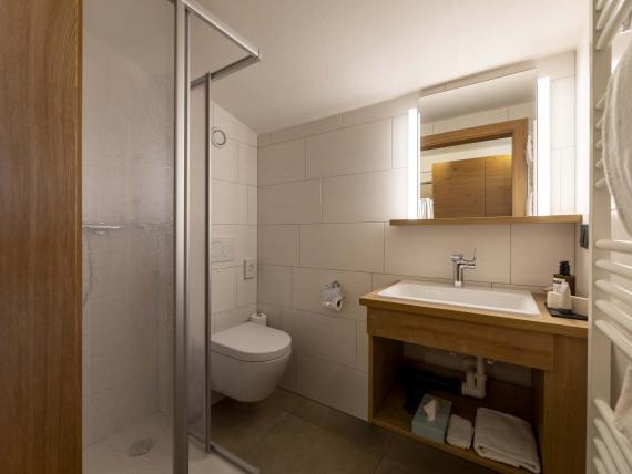 Bagno moderno all'Unterrain Lifestyle Hotel con dettagli in legno e doccia