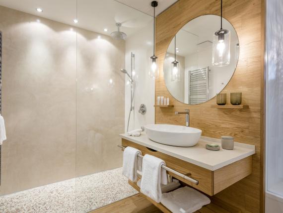 Modernes Badezimmer im Seezeitlodge Hotel & Spa mit Walk-in Dusche und Holzvertäfelung