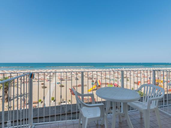 Balcone con fiori e vista sulla spiaggia e il mare con cielo sereno