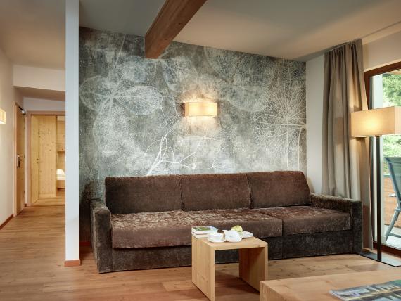 Wohnzimmer mit brauem Sofa im Naturhotel Die Waldruhe