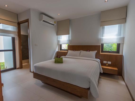 Cozy bedroom with white bedding at The Mangosteen Ayurveda & Wellness Resort