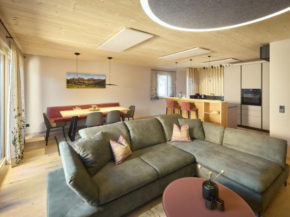 Wohnzimmer mit grünem Ecksofa und Essbereich im Hochfeldhof