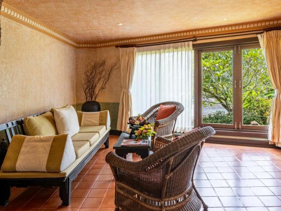 Cozy room interior at The Mangosteen Ayurveda & Wellness Resort with seating area and soft lighting