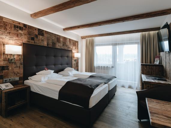 DER GREIL Hotelzimmer mit Doppelbett, Stühlen und Tisch in modernem Design