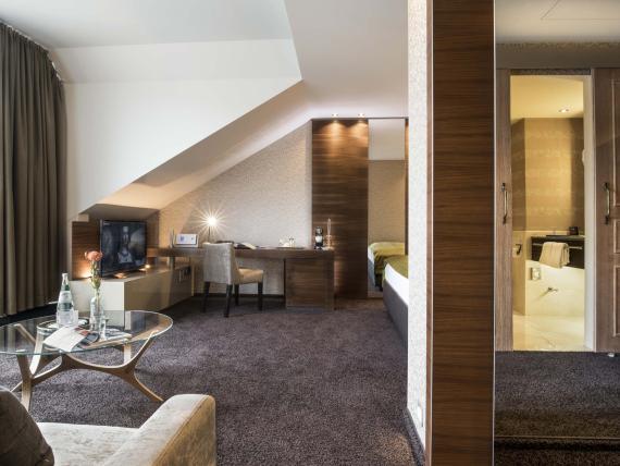 Innenansicht eines modernen Hotelzimmers im Land & Golf Hotel Stromberg mit Schreibtisch und Bad