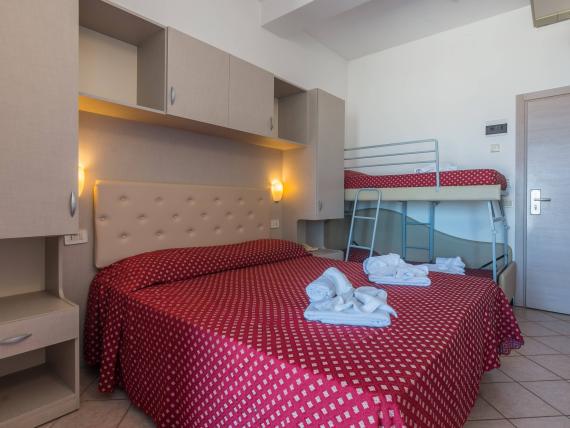 Camera da letto con coperte rosse a fiori e mobili moderni