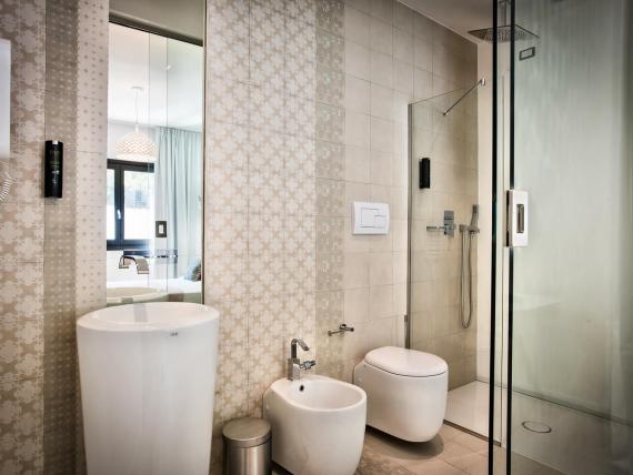 Bagno moderno con doccia, lavabo e WC al Teku Boutique Hotel