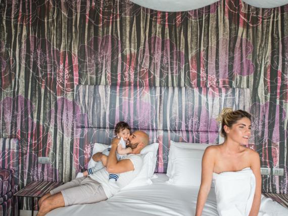 Famiglia nella camera dell'Hotel Bibione Palace con tende colorate sullo sfondo