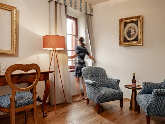 Gemütlicher Sitzbereich mit Stühlen und Tisch in einem Zimmer von Castel Sallegg