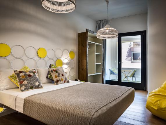 Camera con letto matrimoniale e dettagli gialli al Teku Boutique Hotel