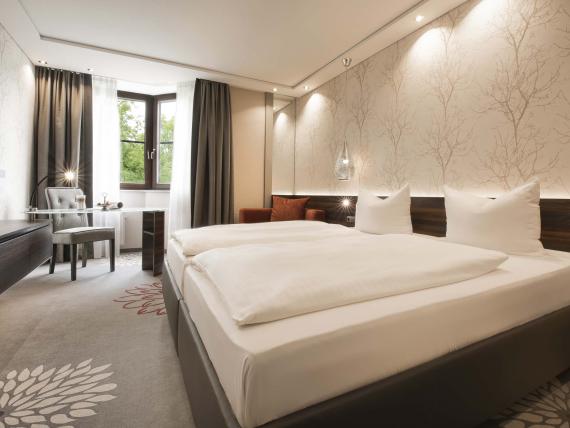 Gemütliches Schlafzimmer im Land & Golf Hotel Stromberg mit Doppelbett und Schreibtisch