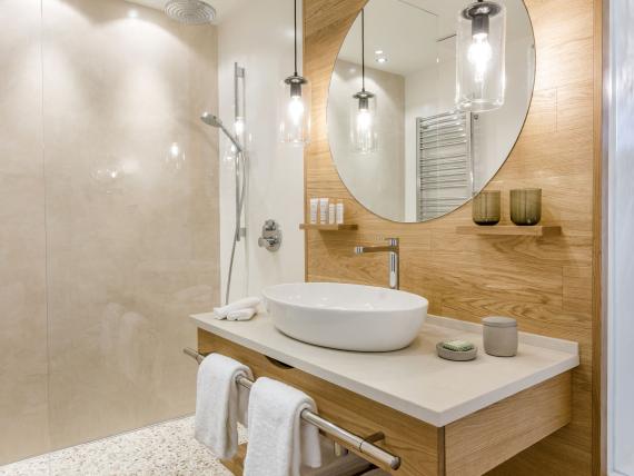 Modernes Badezimmer im Seezeitlodge Hotel & Spa mit Dusche und Holzakzenten
