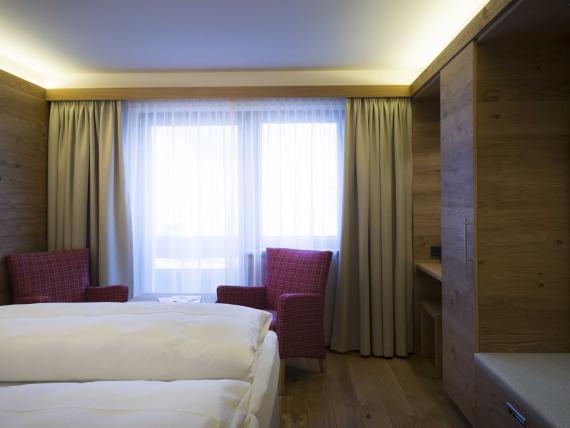 Hotel Panorama: Modernes Hotelzimmer mit Doppelbett, Sesseln und Fenster
