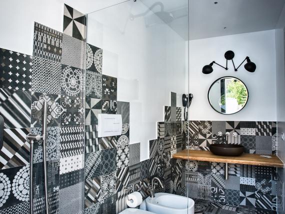 Bagno moderno con piastrelle decorate, doccia e lavabo al Teku Boutique Hotel