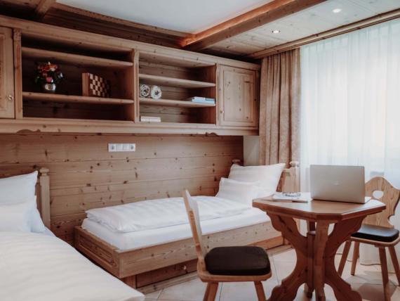 Gemütliches Zimmer mit Holzmöbeln und Betten im Das Verwall Lech