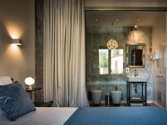 Camera del Teku Boutique Hotel con biancheria blu e bagno adiacente